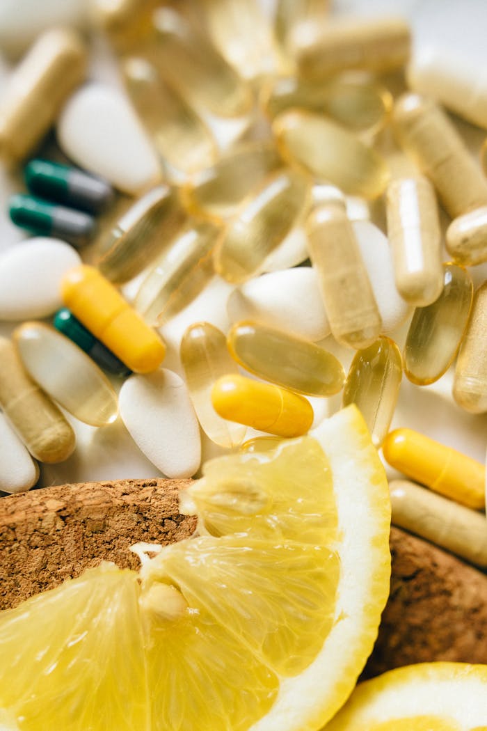 Services-02 Close-up of assorted vitamins, supplements, and lemon slices on a cork surface.